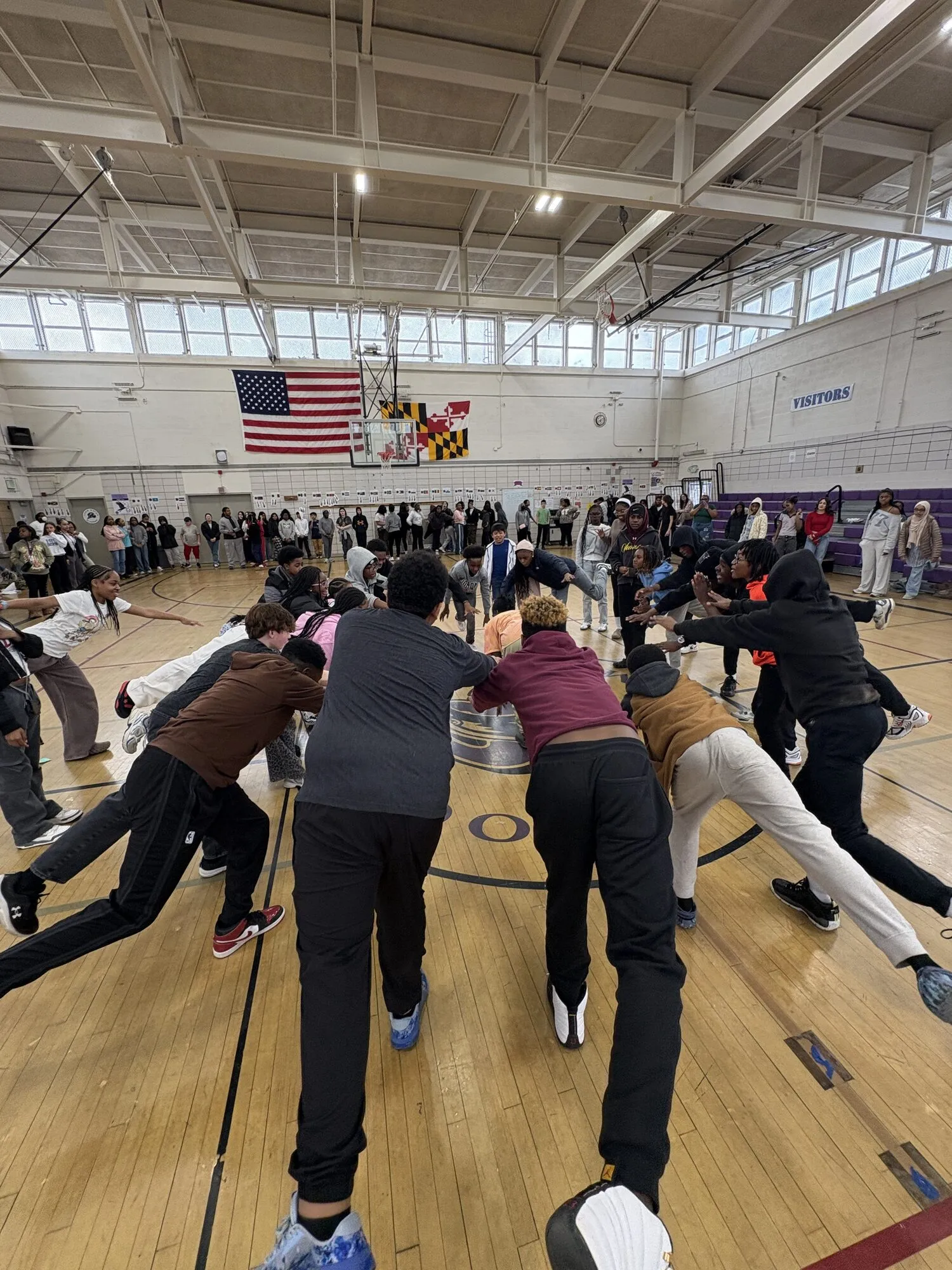 A large school assembly gathered in a gymnasium