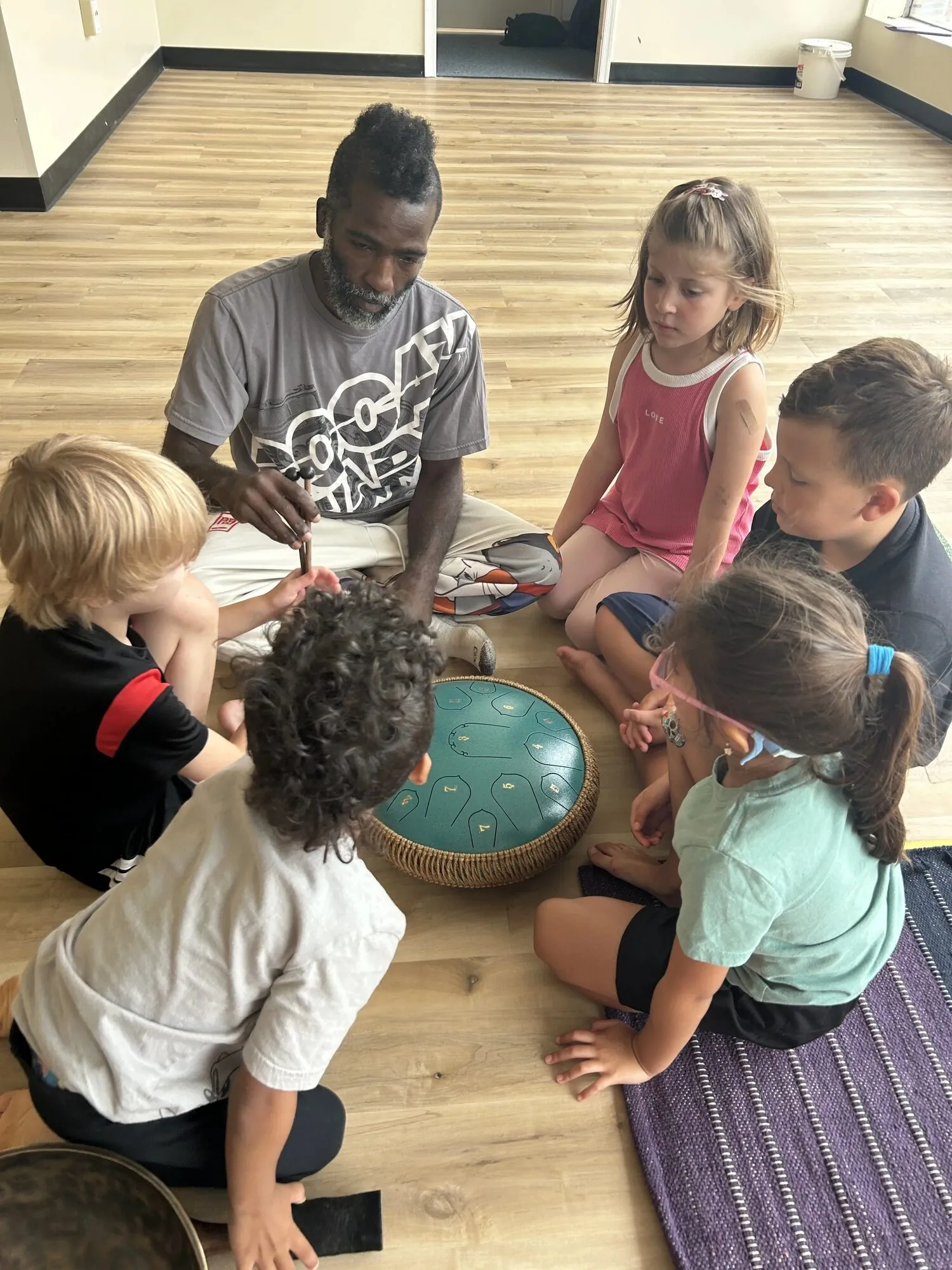 Children working together at a craft table during a Yoga Mouth session
