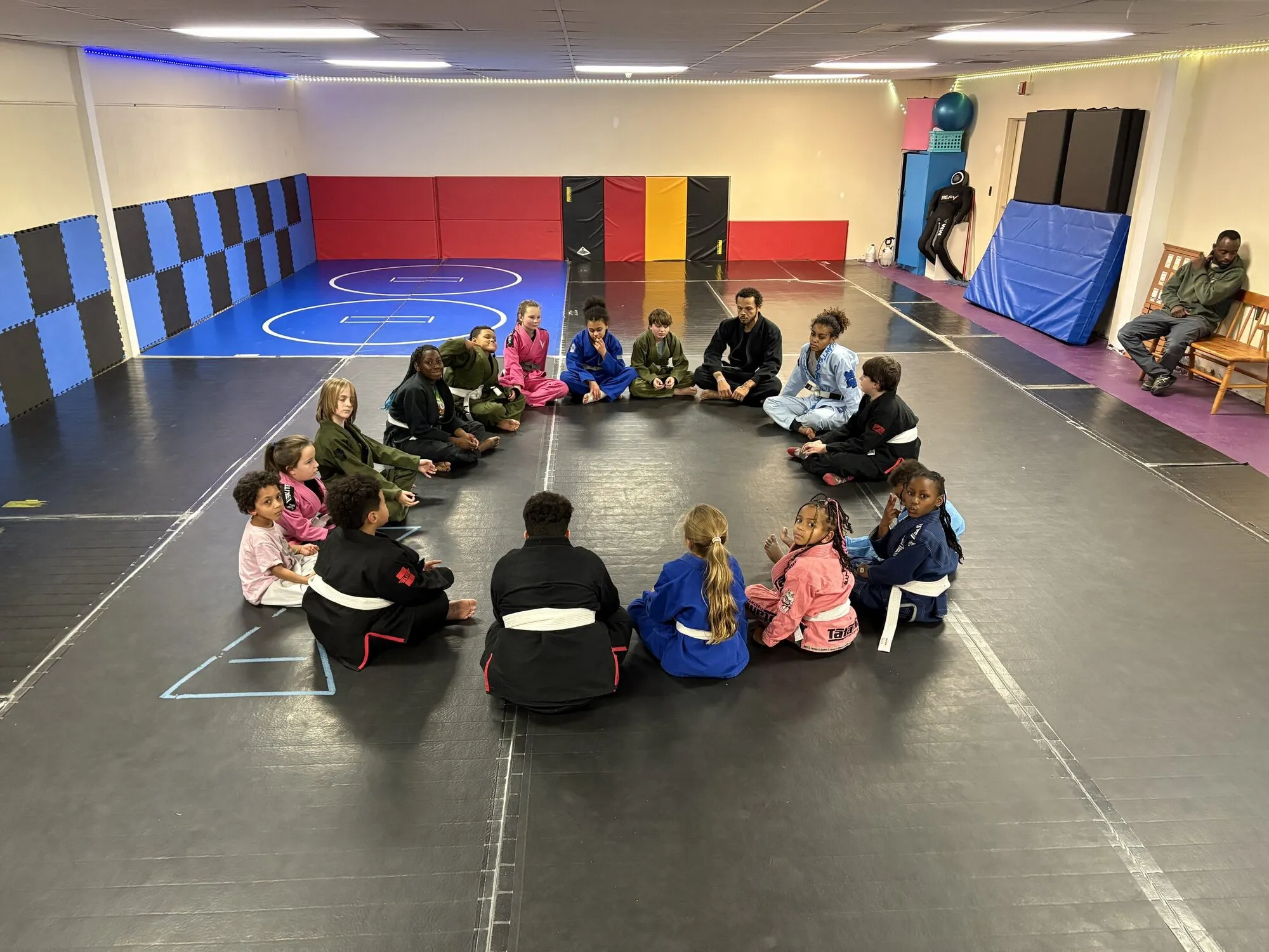 Students and staff gathered in a wide circle in a school gymnasium